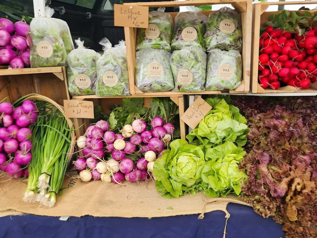 A person carrying a basket of flowers at the Blue Hill Market.